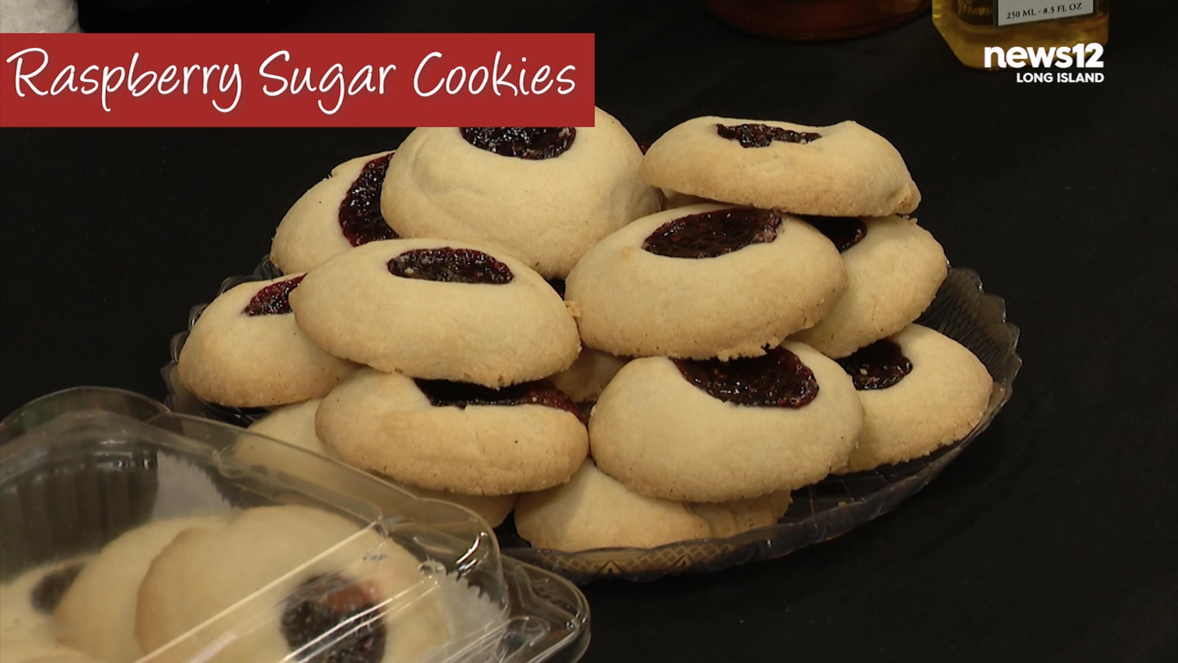 Raspberry sugar cookies on a glass dish on black background